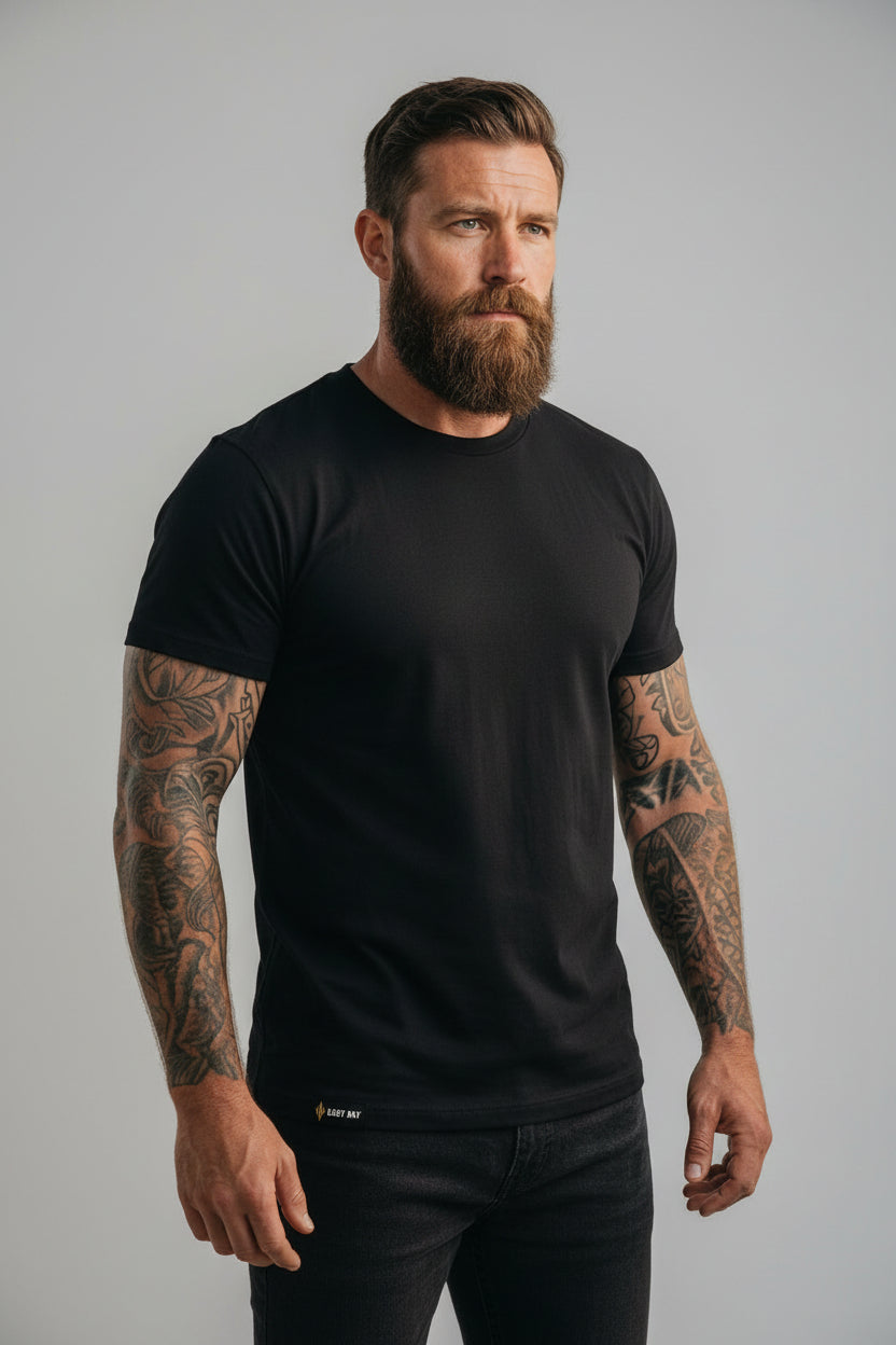 Man wearing the Easy Day Core black heavyweight cotton tee, front view showing the gold hem tag