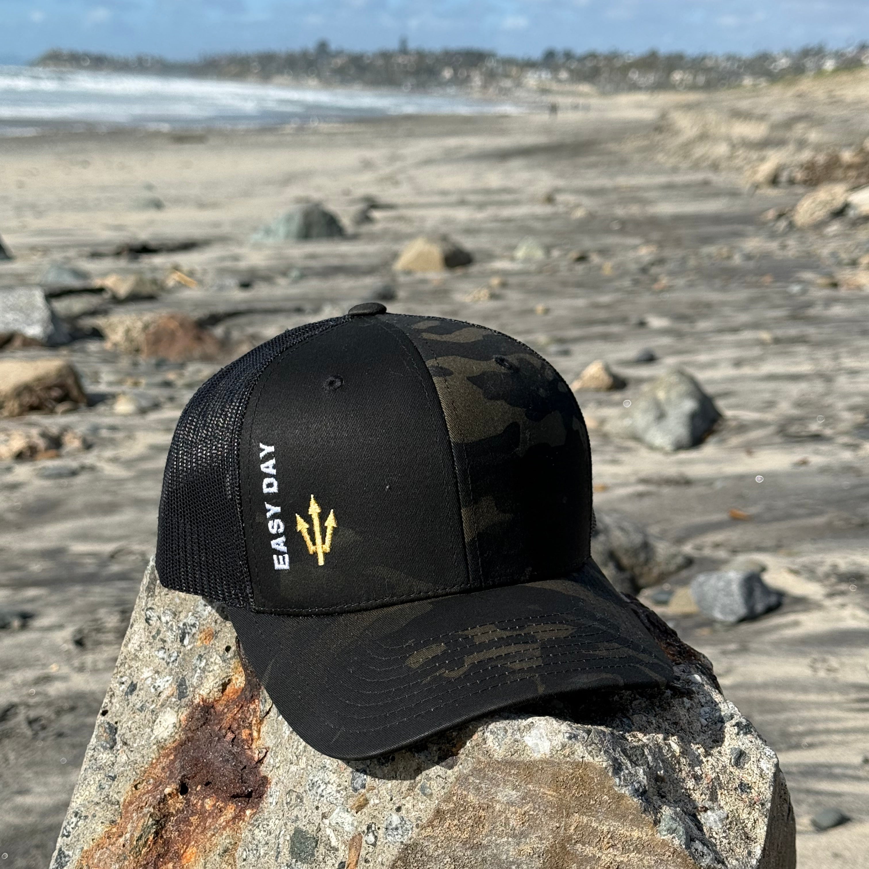 Black cap with a logo on a stone surface