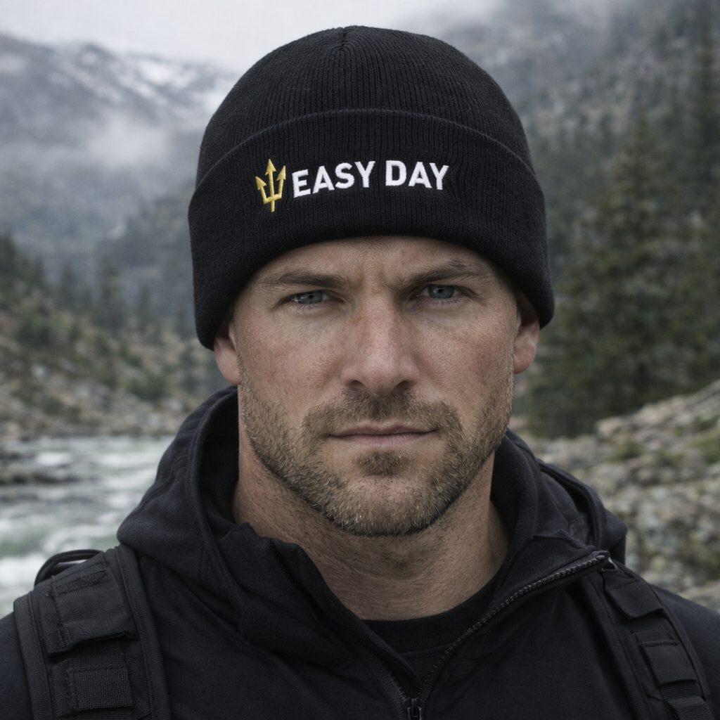 Man wearing a black cap with 'Easy Day' logo in a mountainous landscape