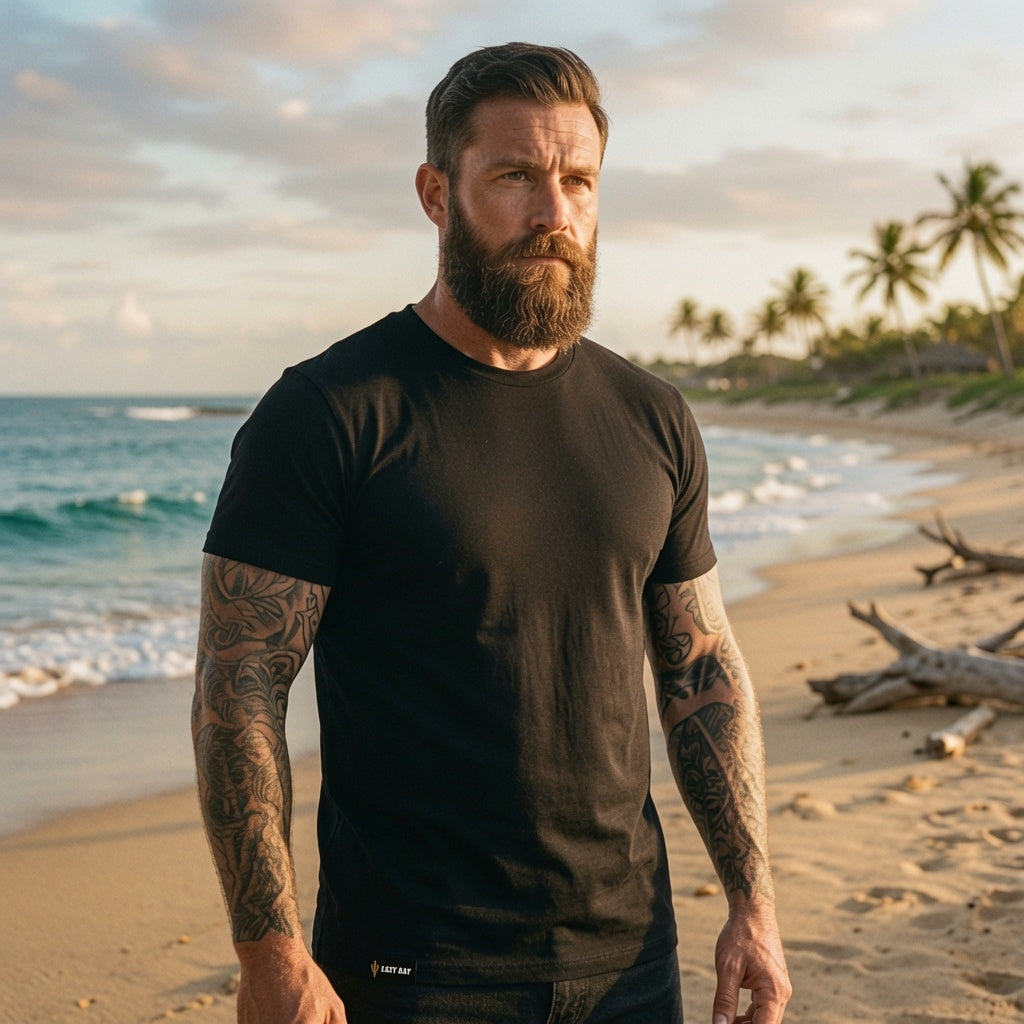 Man wearing the Easy Day Core black heavyweight cotton tee on a beach at sunset