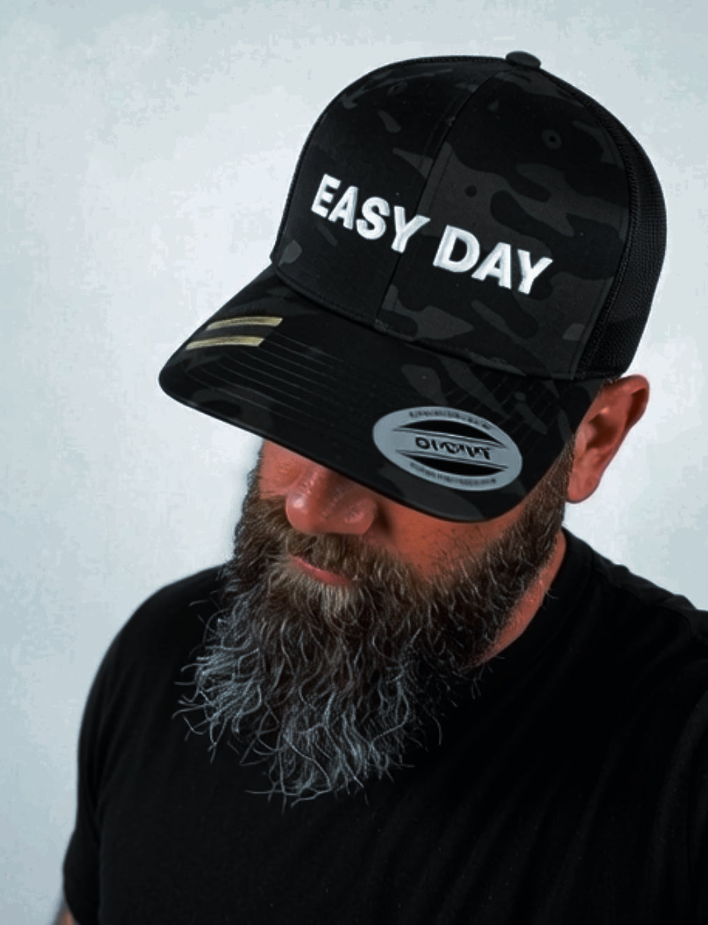 Man wearing a black cap with 'EASY DAY' text on a light gray background