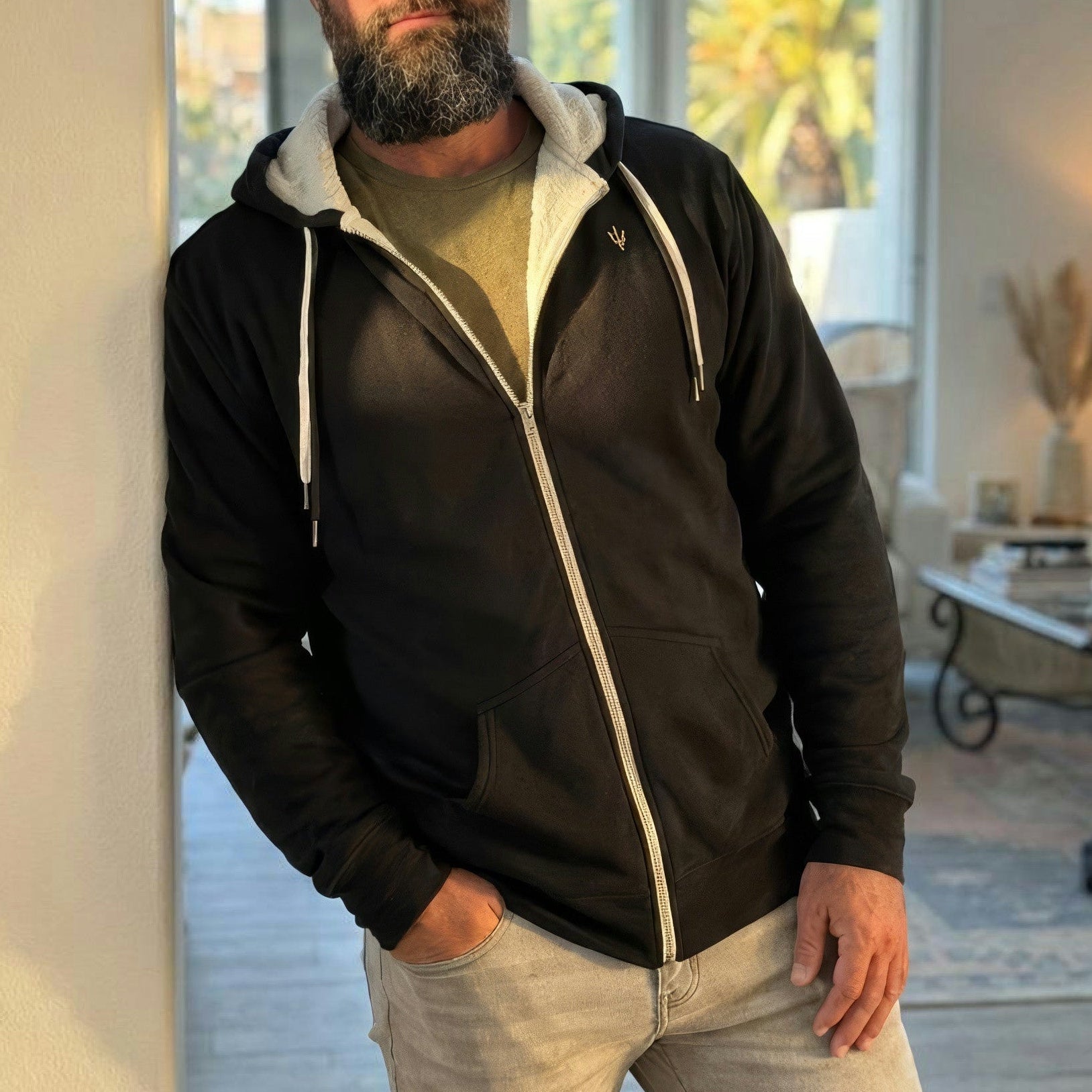 Man wearing a black easy day trident sherpa zip up in a living room setting
