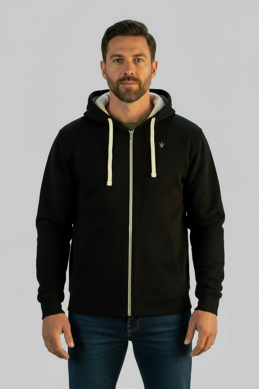 Man wearing a black easy day trident sherpa zip up in a living room setting